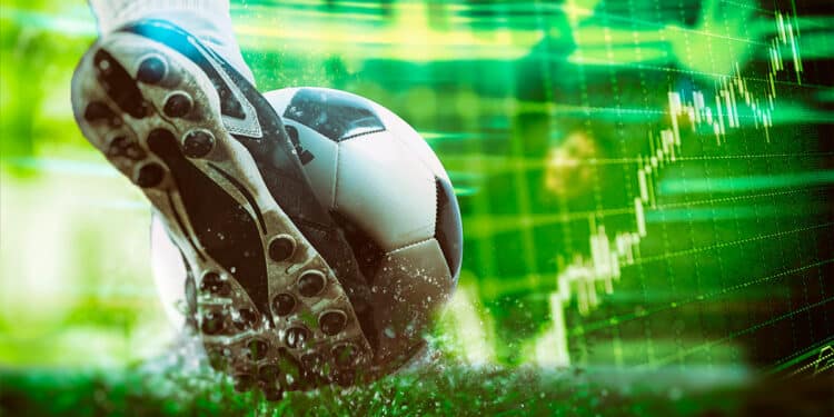 juador de futbol pateando balón hacia gráfico de mercado en verde