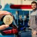 Mano muestra moneda de bitcoin con hombre cargando gasolina a su automovil en el fondo