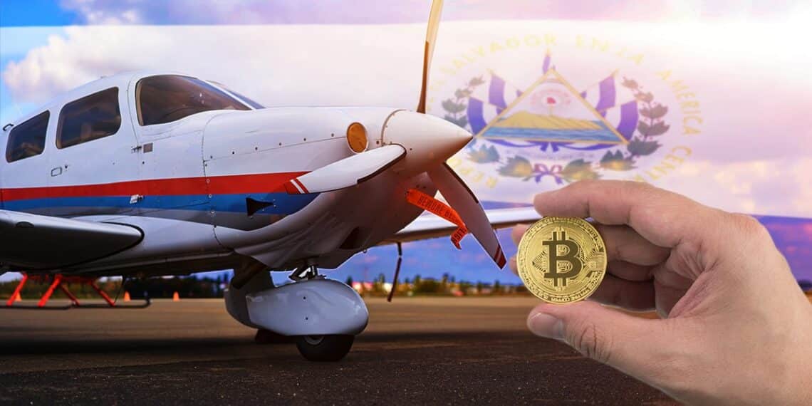 mano sosteniendo moneda de bitcoin con avioneta estacionada y bandera de El Salvador en el fondo