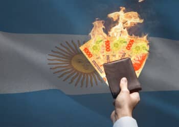 Pesos argentinos en llamas con bandera de Argentina