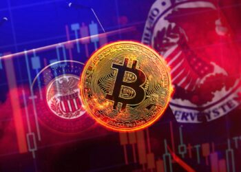 moneda de bitcoin con gráfico de precio bajista y estrado de anuncios de la fed en el fondo