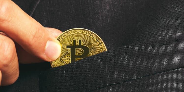 hombre depositando moneda de bitcoin en bolsillo de chaqueta
