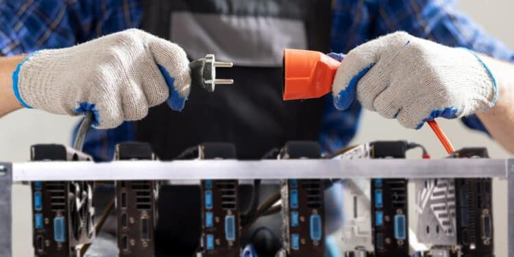 hombre desconectando cables eléctricos con rigs de minería de ethereum