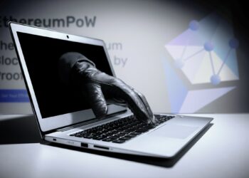 mano atravesando pantalla de computadora con logo y página falsa de ethereum pow