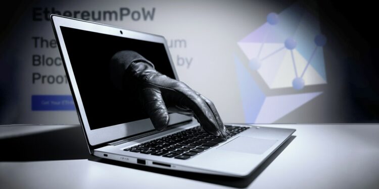 mano atravesando pantalla de computadora con logo y página falsa de ethereum pow