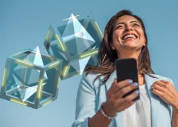 mujer sonriendo al teléfono con bloques de ethereum fusionandose en el fondo