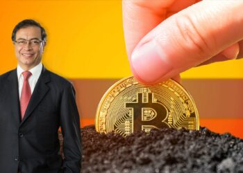 Gustavo Petro en junto a mano sosteniendo moneda de bitcoin