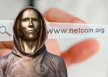 Estatua de Satoshi Nakamoto junto al dominio inicial de bitcoin.