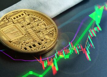 criptomoneda sobre mesa con gráfico de precio alcista en el fondo