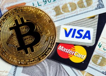 moneda de bitcoin sobre tarjetas de visa y mastercard