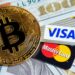 moneda de bitcoin sobre tarjetas de visa y mastercard