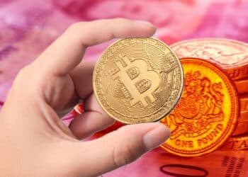 Libra esterlina en rojo y mano sosteniendo btc