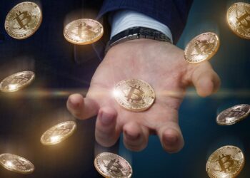 monedas de bitcoin cayendo con hombre sosteniendo bitcoin