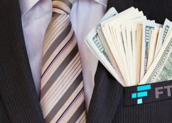 Persona en traje con logo de FTX y billetes en el bolsillo