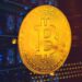 moneda de bitcoin sober placa de metal con mineros asic en el fondo.