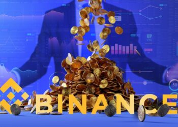 logo de binance en frente de monedas de bitcoin apilandose con gráficos de reporte y persona en el fondo