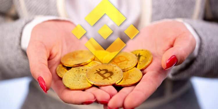 mujer sostiene monedas de bitcoin entre sus manos con logo de binance