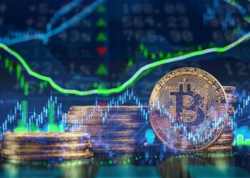 moneda de bitcoin con gráfico lateralizado y mercado de acciones con ráfico creciente en el fondo