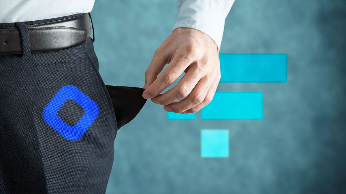 Persona con bolsillos vacíos y logo de BLockfi en pantalón y logo de FTX al fondo