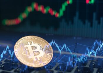 moneda de bitcoin sobre computadora con gráfico de precio superpuesto y gráfico de mercado en el fondo