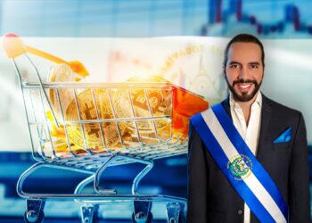 Nayib Bukele, presidente de El Salvdor en frente de carrito de mercado lleno de bitcoins frente a pantalla con gráfico de mercado y bandera de El Salvador superpuesta.