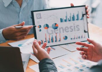 personas discuten gráficos empresariales con logo de Genesis Global Capital