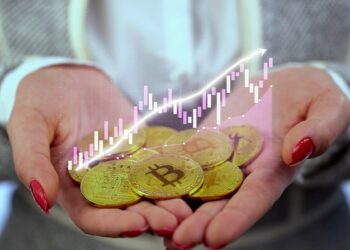 mujer sostiene monedas de bitcoin con gráfico creciente superpuesto