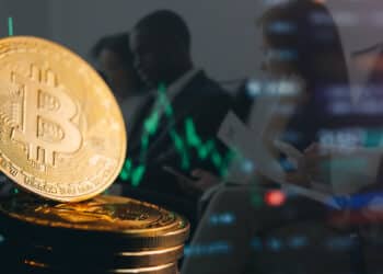 moneda de bitcoin con gráfico decreciente en el fondo con personas esperando