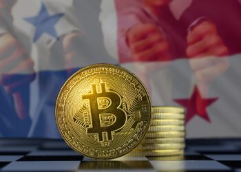 moneda de bitcoin sobre mesa con bandera de panamá en el fondo y personas mostrando rechazo