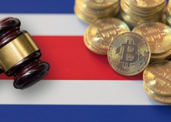 martillo de juez con monedas de bitcoin sobre bandera de Costa Rica