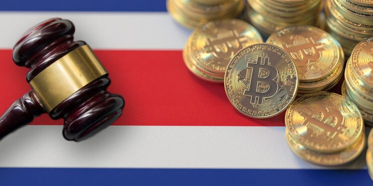 martillo de juez con monedas de bitcoin sobre bandera de Costa Rica