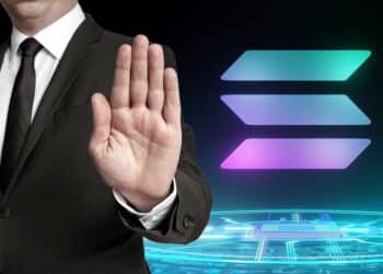 hombre muestra señal de rechazo con logo de Solana sobre platafoma digital en el fondo