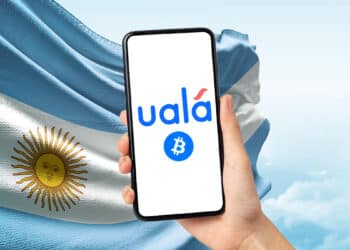 Aplicación de Uala junto a bandera de Argentina y bitcoin.