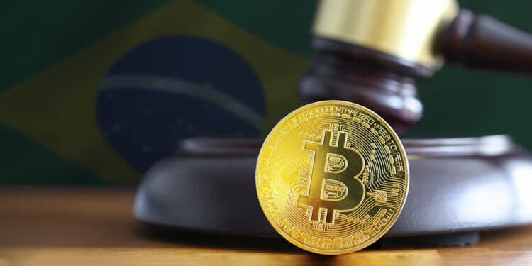 moneda de bitcoin sobre mesa en frente de martilllo de juez con bandera de brasil en el fondo