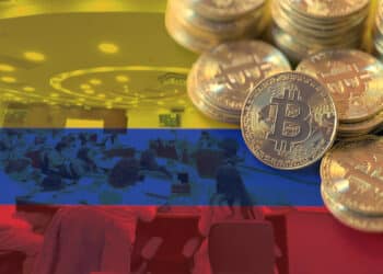 monedas de bitcoin apiladas sobre bandera de colombia con camara de diputados en el fondo