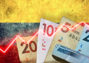 Bandera de colombia y pesos colombianos con gráfico rojo en alza representando la inflación