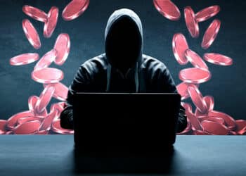 Estafador con laptop y tokens rojos
