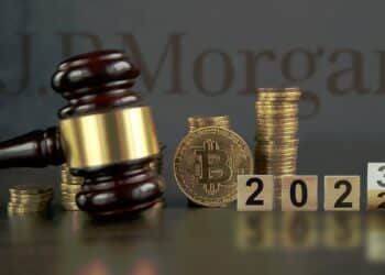 moneda de bitcoin entre martillo de juez y cubos marcando el 2023 con logo de JP Morgan en el fondo