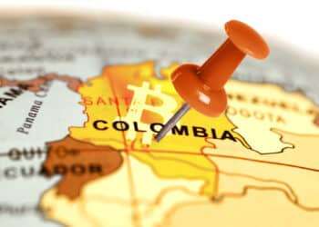 alfiler clavado en mapa mundi sobre ubiación de Colombia con logo de Bitcoin