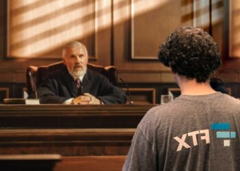 Sam Bankman-Fried de espaldas con logo de FTX en camiseta, ante juez durante juicio