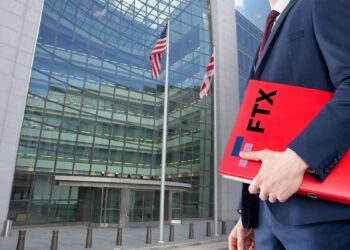 hombre sosteniendo carpeta con logo de FTX sirigiendose a oficinas de la SEC