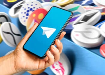 Fondo de criptomonedas y teléfono con logo de Telegram