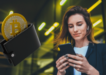 Mujer con su celular junto a una wallet con bitcoin.