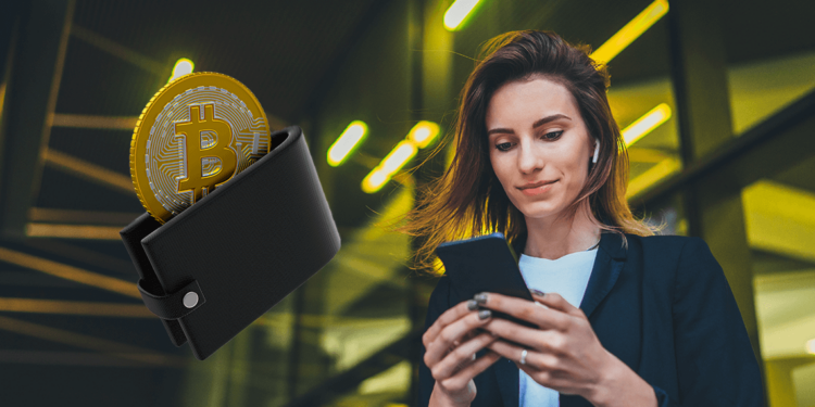 Mujer con su celular junto a una wallet con bitcoin.