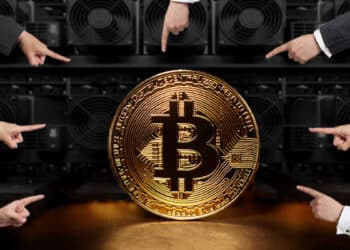 moneda e Bitcoin señalada por manos con mineros en el fondo