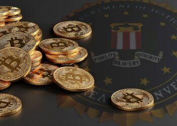 Monedas de bitcoin sobre mesa con logo del FBI