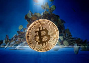 Bitcoin con monedas cayendo detrás.