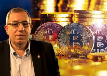 Carlos Maslatón junto con monedas de bitcoin y monedas apiladas en el fondo