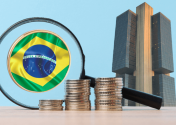 Moneda de Brasil junto a una lupa y el Banco central de Brasil.