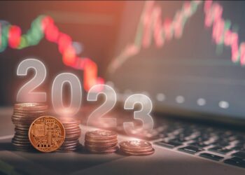 criptomoneda apoyada en monedas apiladas con 2023 superpuesto y gráficos de precio bajista en el fondo